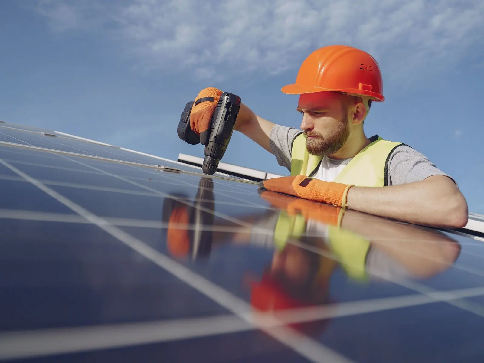 Electricista con casco instalando un panel solar