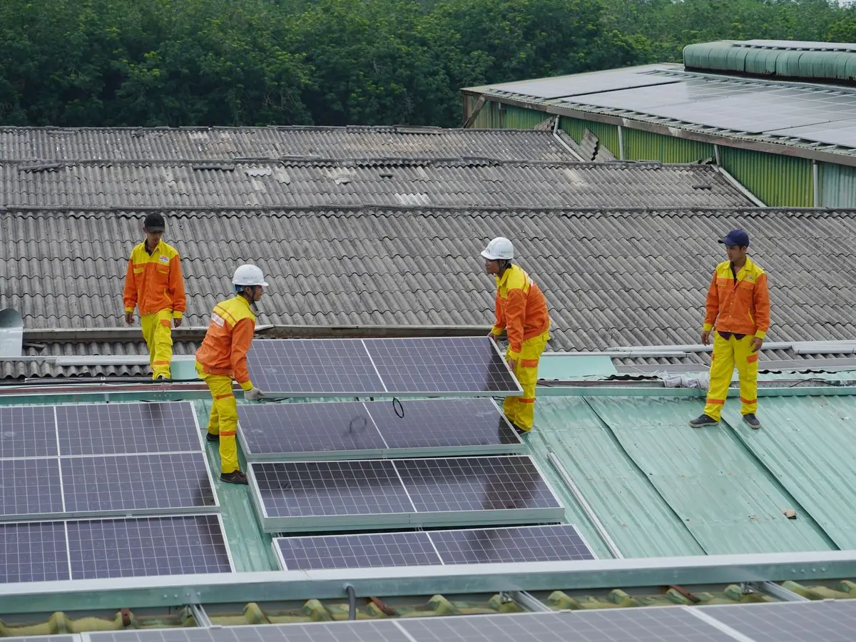 Equipo instalando paneles solares en un techo de chapa