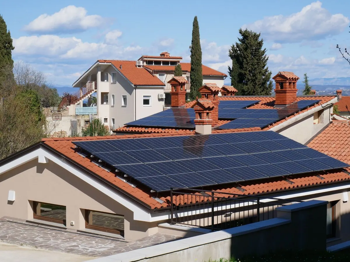 Casa de techo de tejas con paneles solares en un barrio residencial
